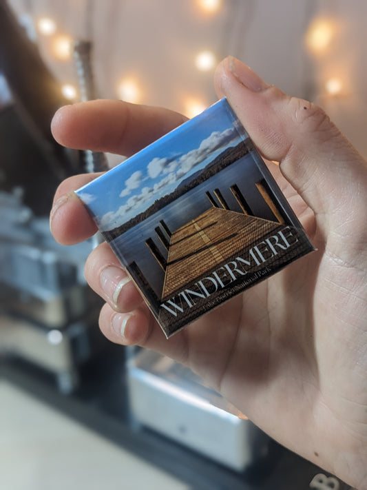 Someone holding a travel souvenir magnets of Windermere in the lake district