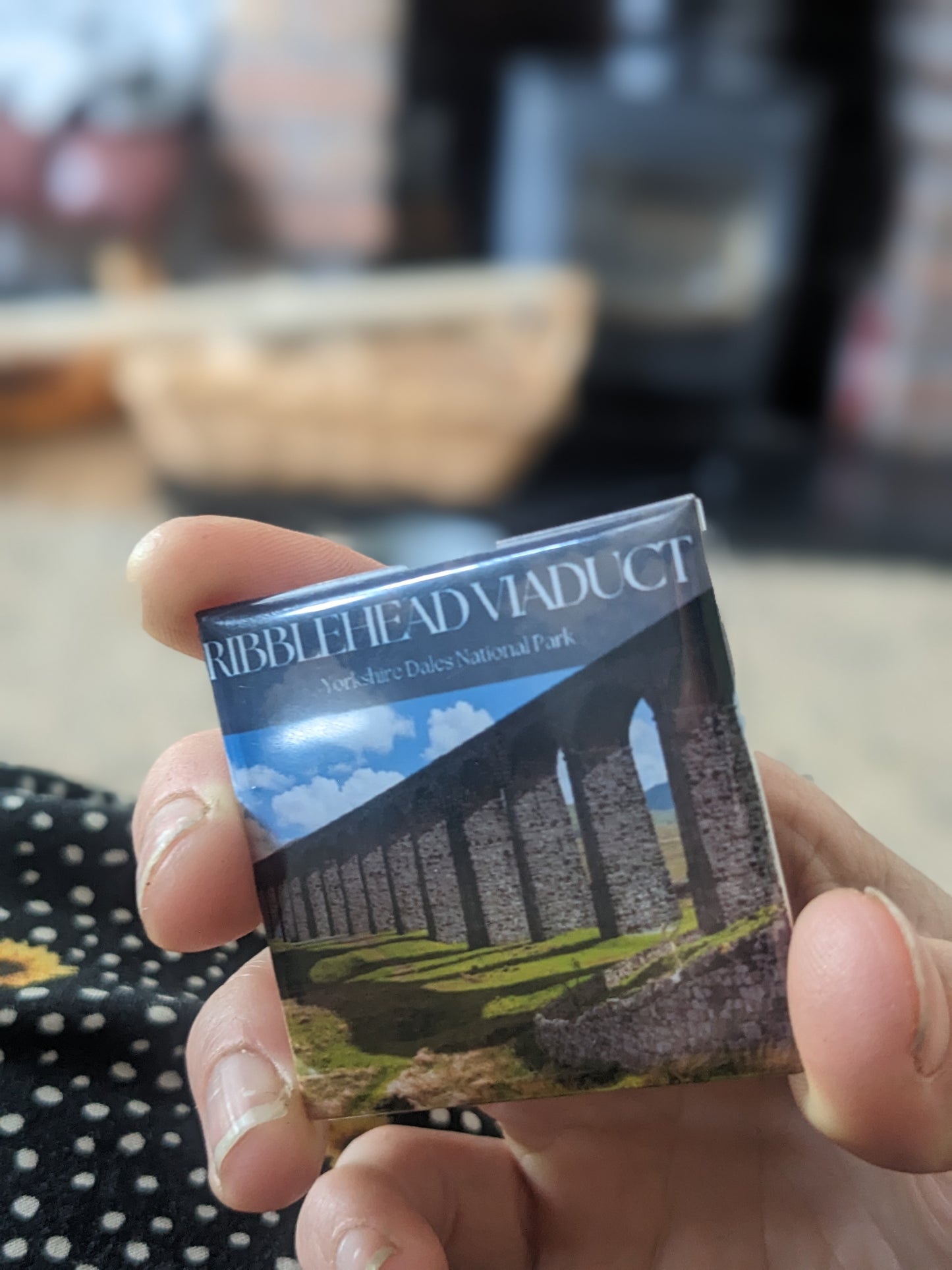 Someone holding one of the travel souvenir magnets of ribblehead viaduct in the Yorkshire dales